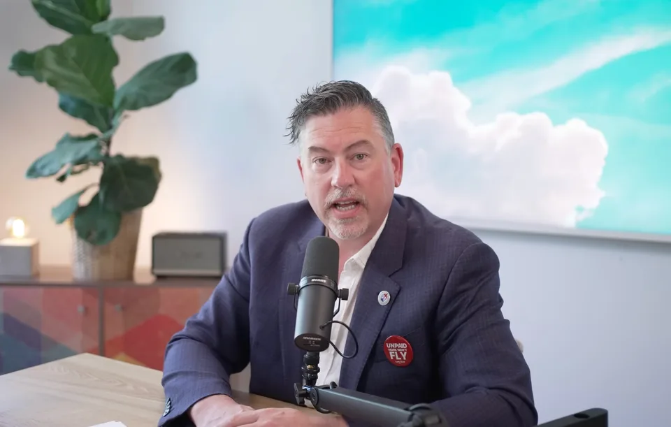 A Flight Plan guest at the mic, wearing an Unpaid Work Won't Fly button